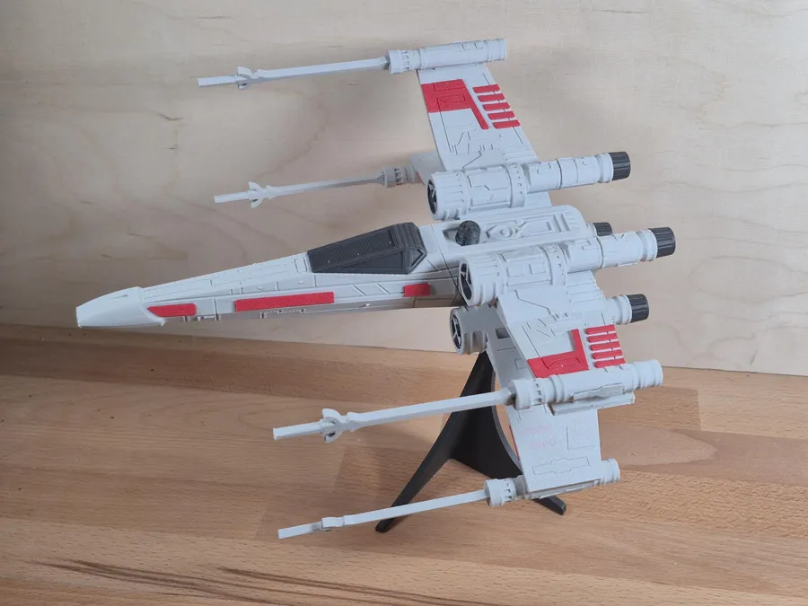 Modèle de vaisseau imprimé en 3D, blanc et rouge, monté sur un socle noir.
